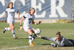 Redshirt senior midfielder Ingrid Wells (9) lofts a shot over Syracuse goalkeeper Brittany Anghel for the Hoyas’ third goal Sunday.