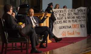 FILE PHOTO: NATE MOULTON/THE HOYA Members of GU Fossil Free hold a banner in Gaston Hall following a speech by World Bank President Jim Yong Kim. GUPD escorted them off the stage.