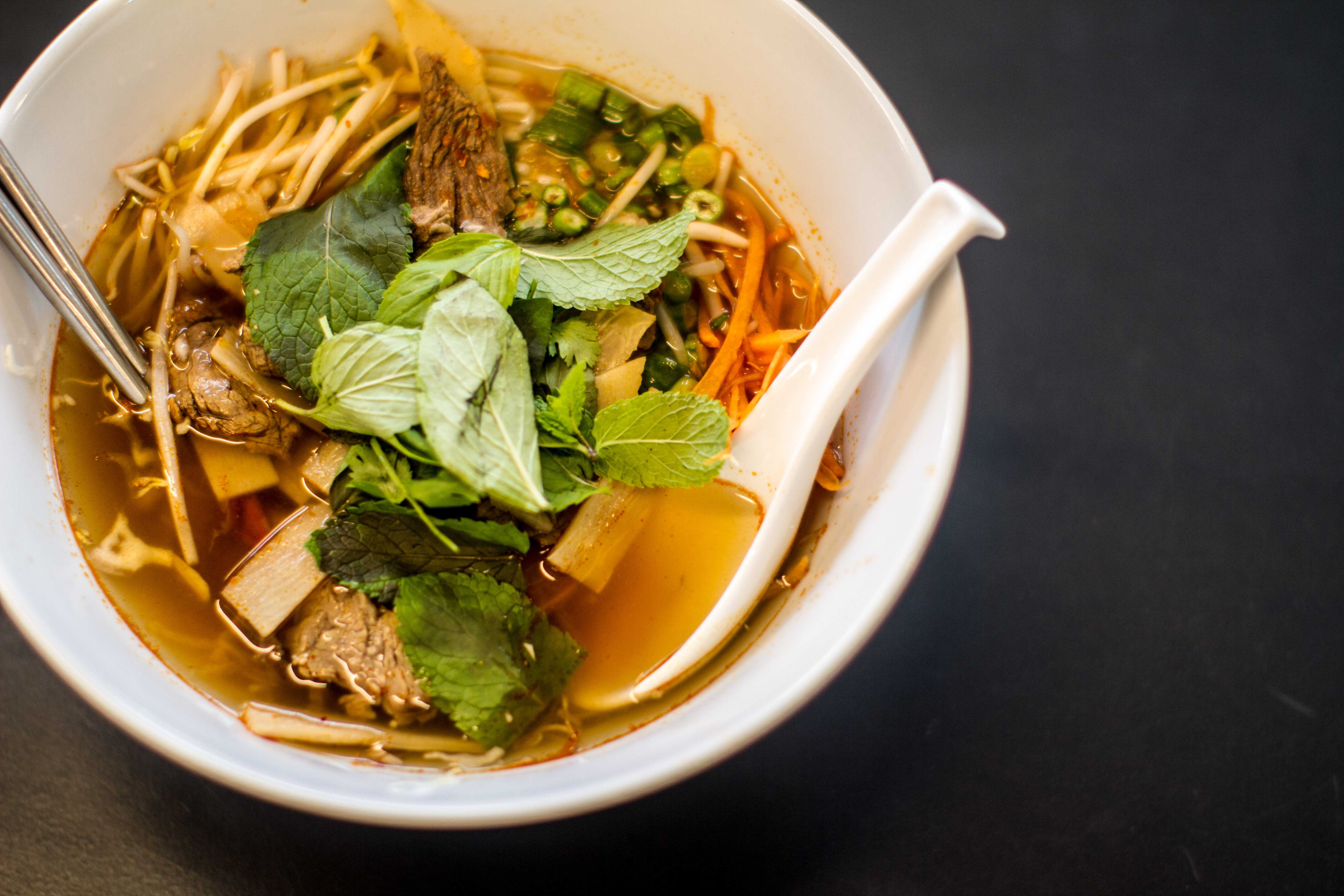 COURTESY FOODHINI Customers of Foodhini seek ethnic foods such as this Laotian soup, Khao Poon Nam Seen, a tomato-based broth with cuts of beef and bamboo, poured over rice noodles with mint and basil.